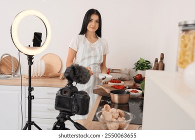 Young woman pouring soup into bowl while recording cooking video class in kitchen - Powered by Shutterstock