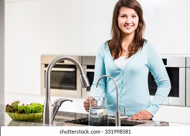 Young Woman Pouring Tap Water To Jag