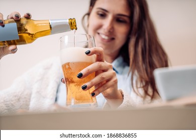 young woman pours a bottled beer into the glass - Powered by Shutterstock