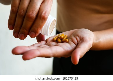 A young woman pours the pills out of the bottle