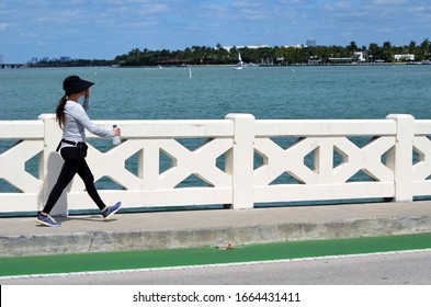 Young Woman Power Walking Across The Venetia Causeway On Miami Beach,Florida.