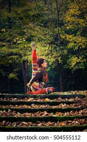 Young Woman Practice Yoga Outdoor In Autumn Park 