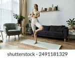 A young woman practices yoga in her apartment, focusing on her inner peace and well-being.