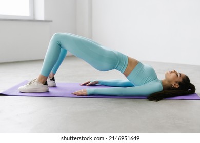 Young Woman Practicing Abdominal Knee Crunches For Upper And Lower Abs Exercise Working Out, Wearing Black Sportswear At Gym