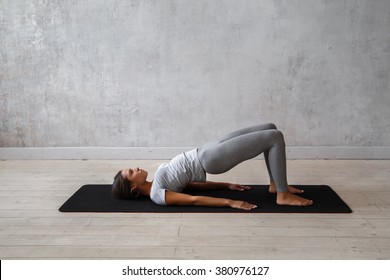 Young Woman Practicing Advanced Yoga. Bridge Pose. Setu Bandha Sarvangasana
