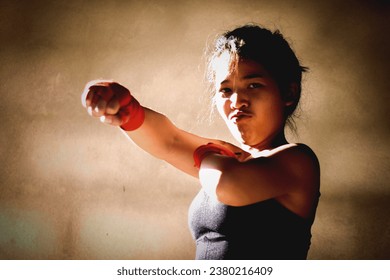 Young woman practicing boxing at the gym, she wears boxing gloves. - Powered by Shutterstock