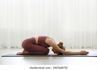 Young Woman Practicing Extended Child Asana In Yoga Studio. Utthita Balasana Pose