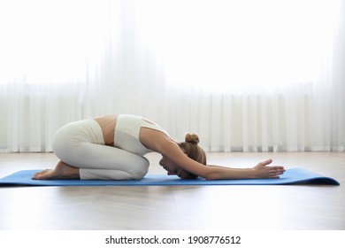 Young Woman Practicing Extended Child Asana In Yoga Studio. Utthita Balasana Pose