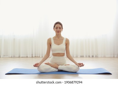 Young woman practicing lotus asana in yoga studio. Padmasana pose - Powered by Shutterstock