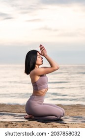 Young woman practicing yoga at the beach at sunrise. Healthy lifestyle. Mind and body exercise