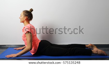 Young woman practicing yoga in the cobra position