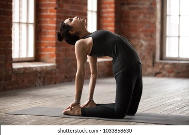 Young Woman Practicing Yoga, Doing Ustrasana Exercise, Camel Pose, Working Out, Wearing Sportswear, Black Pants And Top, Indoor Full Length, Yoga Studio