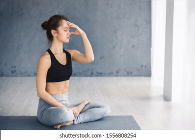 Young Woman Practicing Yoga, Doing Alternate Nostril Breathing Technique In Studio, Free Space