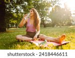 Young woman practicing yoga during workout in park. Fitness. Active lifestyle.