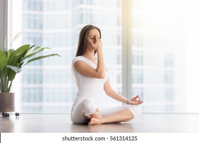 Young Woman Practicing Yoga Exercise, Sitting In Sukhasana Pose, Alternate Nostril Breathing Technique, Nadi Shodhana Pranayama, Working Out, Wearing White Sportswear, Indoor Full Length 