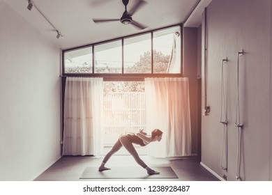 Young woman practicing yoga in  gray background.Young people do yoga indoor.Top view of beautiful young fitness woman working out .