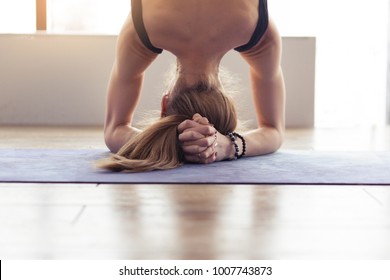 Young woman practicing yoga headstand pose, close-up on head - Powered by Shutterstock