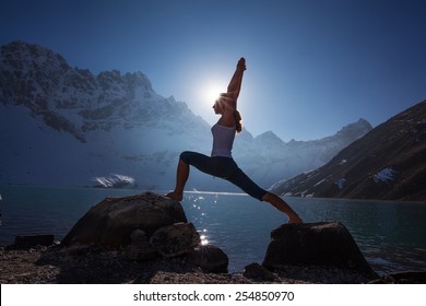 Young Woman Is Practicing Yoga At Mountain Lake