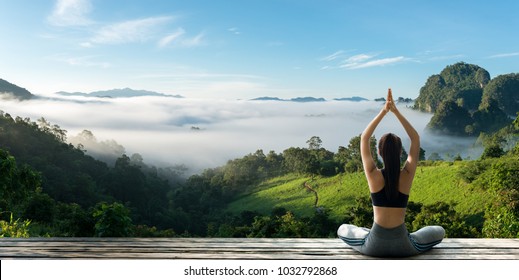 Young woman practicing yoga in the nature.female happiness. Landscape background - Shutterstock ID 1032792868