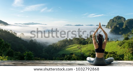 Young woman practicing yoga in the nature.female happiness. Landscape background