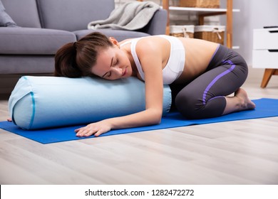 Young Woman Practicing Yoga On Bolster At Home