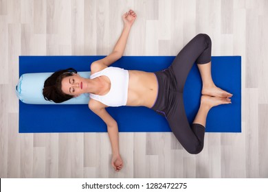 Young Woman Practicing Yoga On Bolster At Home