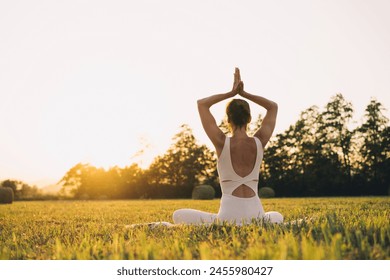 Young woman practicing yoga on nature. Girl meditating outdoors. Female with slim, strength and flexibility body. Healthy lifestyles. Concept of vitality, calmness, relax, mindfulness, zen energy. - Powered by Shutterstock