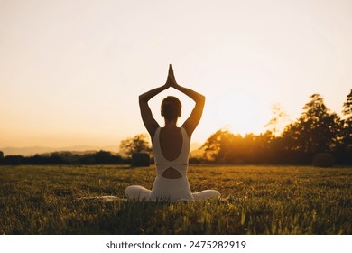 Young woman practicing yoga on nature. Girl meditating outdoors. Female with slim, strength and flexibility body. Healthy lifestyles. Concept of vitality, calmness, relax, mindfulness, zen energy.