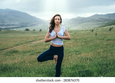 Young woman practicing yoga outdoor in the nature