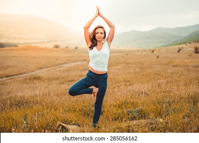Young woman practicing yoga outdoor in the nature