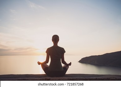 Young woman practicing yoga outdoors. Harmony, self care, relaxation exercises,  healthy lifestyle and meditation concept. - Shutterstock ID 721857268