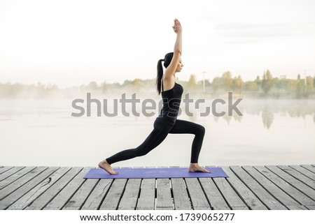 Similar – Active slim young woman doing yoga by the lake