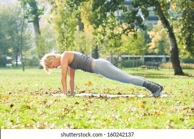 Young woman practicing yoga in the park,Yoga-Dandasana /Plank pose - Powered by Shutterstock