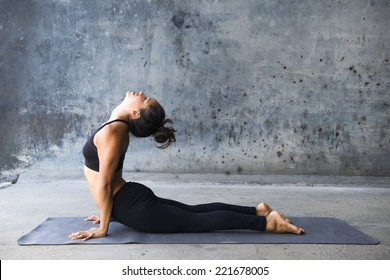 Young woman practicing yoga in a urban background - Powered by Shutterstock