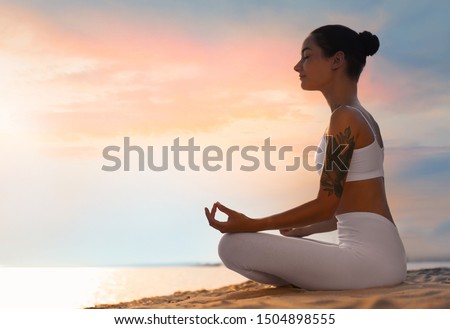 Young woman practicing zen meditation on beach. Space for text