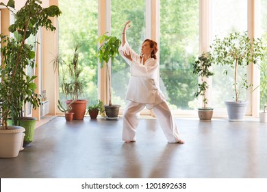 Young Woman praticing tai chi chuan in the home. Chinese management skill Qi's energy.