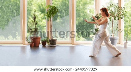 Young Woman praticing tai chi chuan in the gym. Chinese management skill Qi's energy. banner. copy space. Healthy lifestyle 