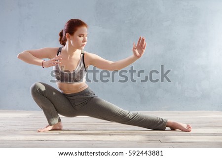 Young Woman praticing tai chi chuan in the gym. Chinese management skill Qi's energy.