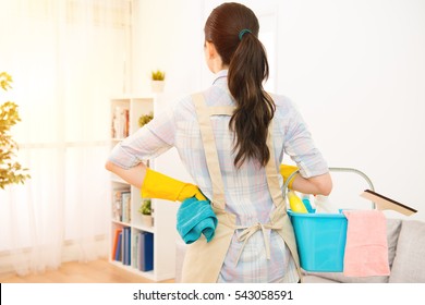 Young Woman Preparing To Clean The Living Room Window Back Face To Camera At Home. Mixed Race Asian Chinese Model.