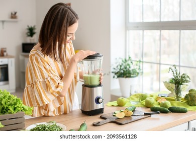 Young woman preparing healthy green smoothie in kitchen - Powered by Shutterstock