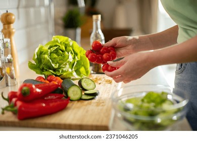 Young woman preparing a healthy organic meal in her kitchen - Powered by Shutterstock