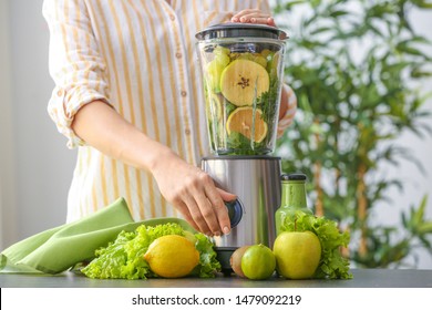 Young Woman Preparing Healthy Smoothie In Kitchen