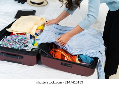 Young Woman Preparing And Packing Clothes Into Suitcase On A Bed At Home, Holiday Travel Concept