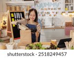 Young woman preparing and packing food in a cozy kitchen setup, with various ingredients and utensils. Concept of cooking and food preparation.