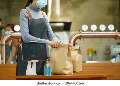 Young Woman Preparing Takeaway  Food Inside Plastic Free Restaurant During Coronavirus Or Covid-19 Outbreak For Online Delivery Service 