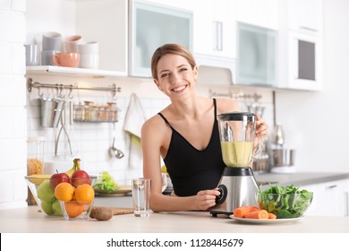 Young Woman Preparing Tasty Healthy Smoothie At Table In Kitchen