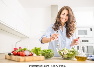 Young woman preparing vegetable salad in her kitchen. Healthy lifestyle concept beautiful woman with mixed vegetable. 