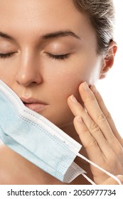 Young Woman With Prevention Mask And Skin Irritation On White Background. Maskne - Acne Breakouts From Wearing A Face Mask.