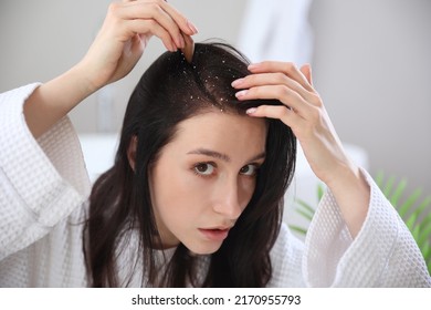 Young Woman With Problem Of Dandruff In Bathroom