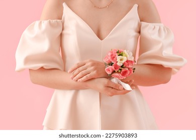 Young woman in prom dress with corsage on pink background, closeup - Powered by Shutterstock